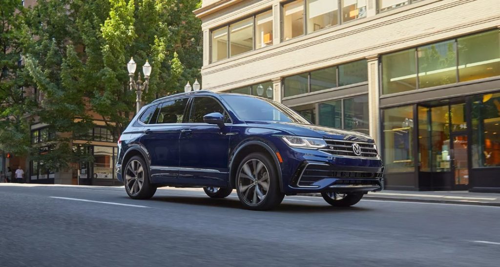 The new Volkswagen Tiguan drives on a city street showcasing it's sleek style. Shop for your new Volkswagen Tiguan near Greenville at Volkswagen of Spartanburg today!