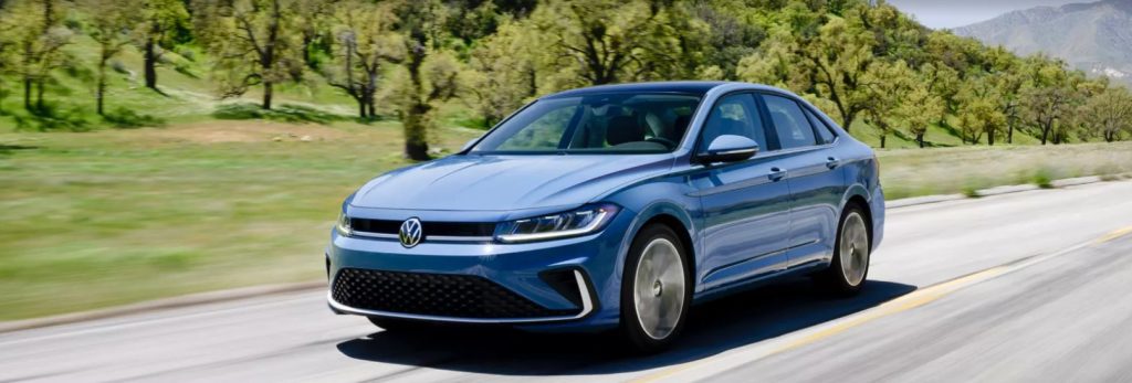 A blue new Volkswagen Jetta is shown driving on an interstate with trees in the background. Shop for your new Volkswagen Jetta near Greenville at Volkswagen of Spartanburg today!
